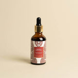 Manjish Glow Night Time Elixir bottle on a plain beige background. Label: Manjish Glow Elixir®. Glow-giving night-time facial massage oil. iYURA