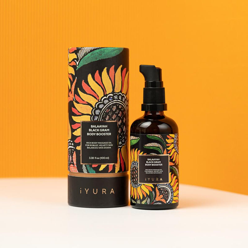 Black Gram Face & Body Duo: the Balaayah Black Gram Body Booster bottle and tube against an orange wall. Label: rich body massage oil for robust, velvety skin, balances vata dosha, 3.38 fl oz (100 ml)