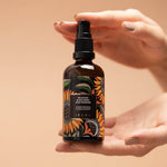 Black Gram Face & Body Duo: the Balaayah Black Gram Body Booster bottle held between two hands, one finger on the pump