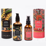 Black Gram Face & Body Duo moisturizers for dry, aging and mature skin by iYURA, 3.38 fl oz (100 ml) and 1.69 fl oz (50 ml): Balaayah Black Gram Body Booster and Yauvari Amplified Youth Spring, each bottle beside its tube, on a white background